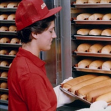 Sandwich Artist taking bread out of oven